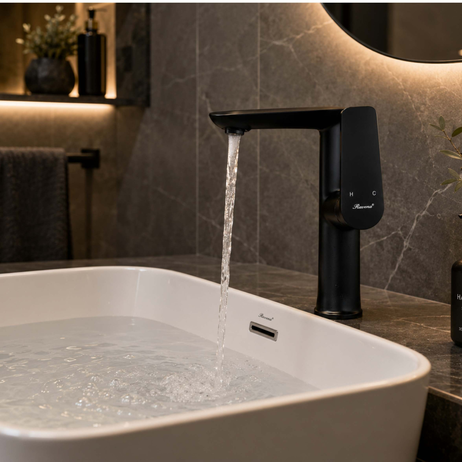 A contemporary matte black faucet running water into a clean white ceramic bathroom basin against a grey marble wall.