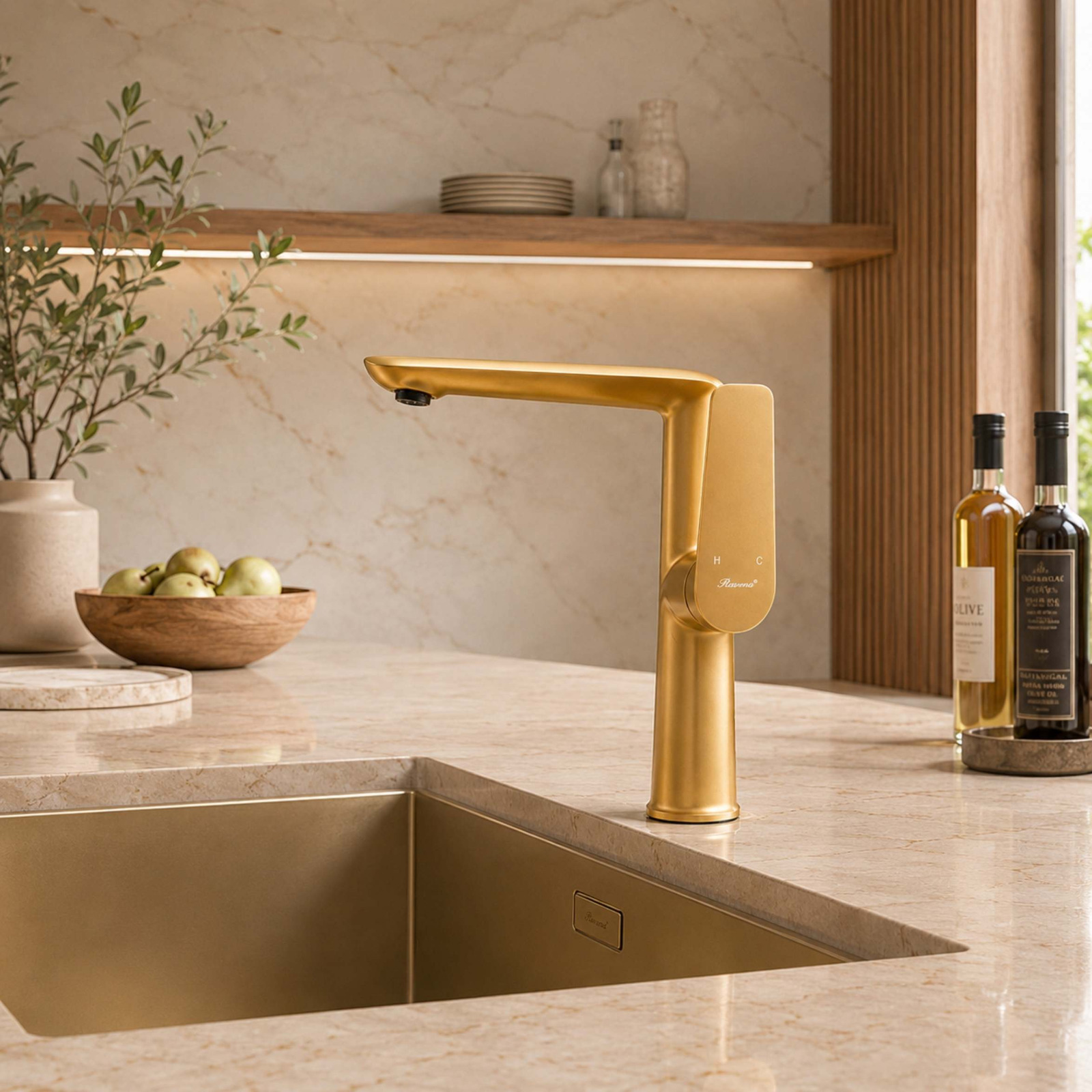 A brushed gold single-lever faucet mounted next to a matching gold undermount sink on a beige stone countertop.