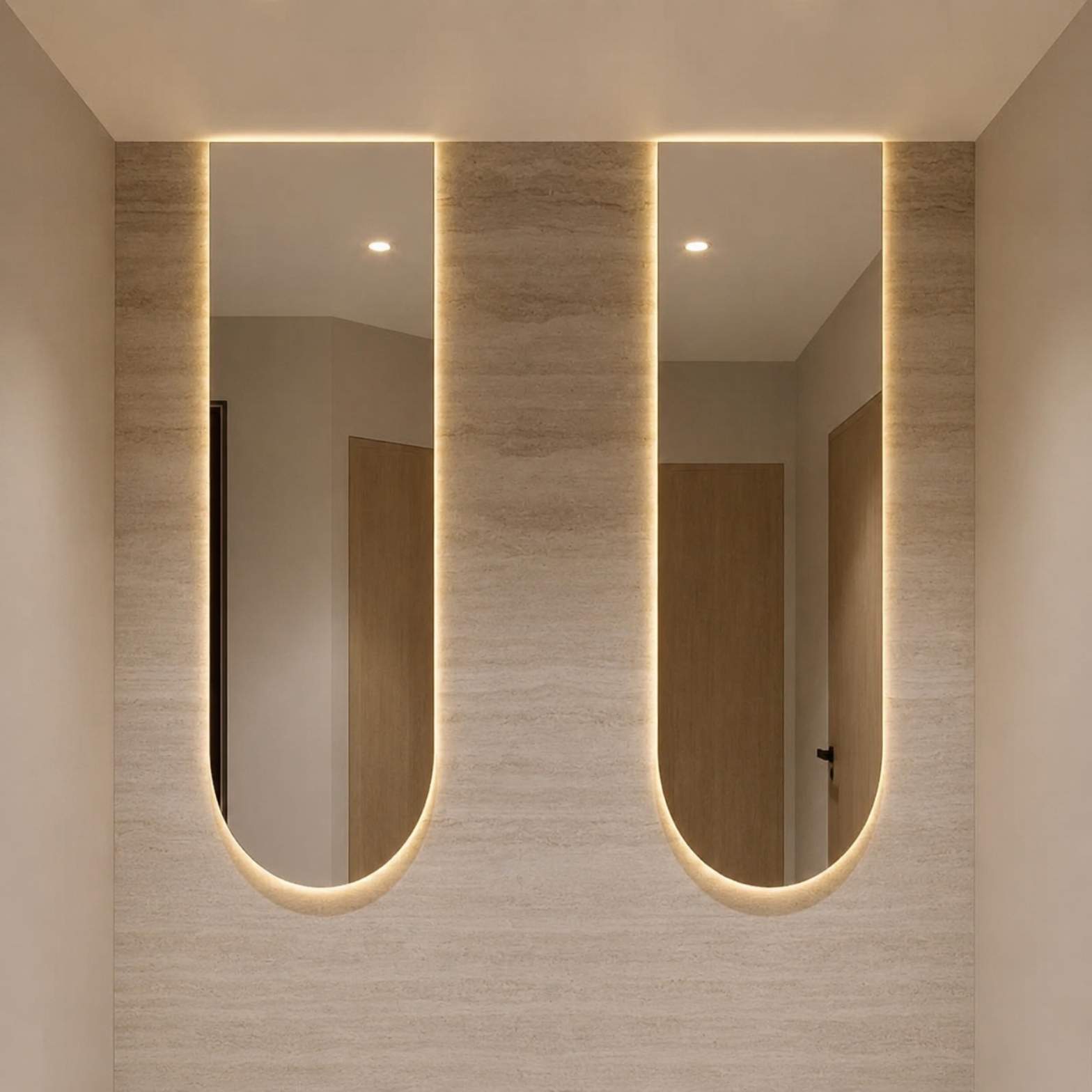 Dual capsule-shaped arch smart mirrors with soft ambient backlighting on a light travertine wall from alwakil.ae 