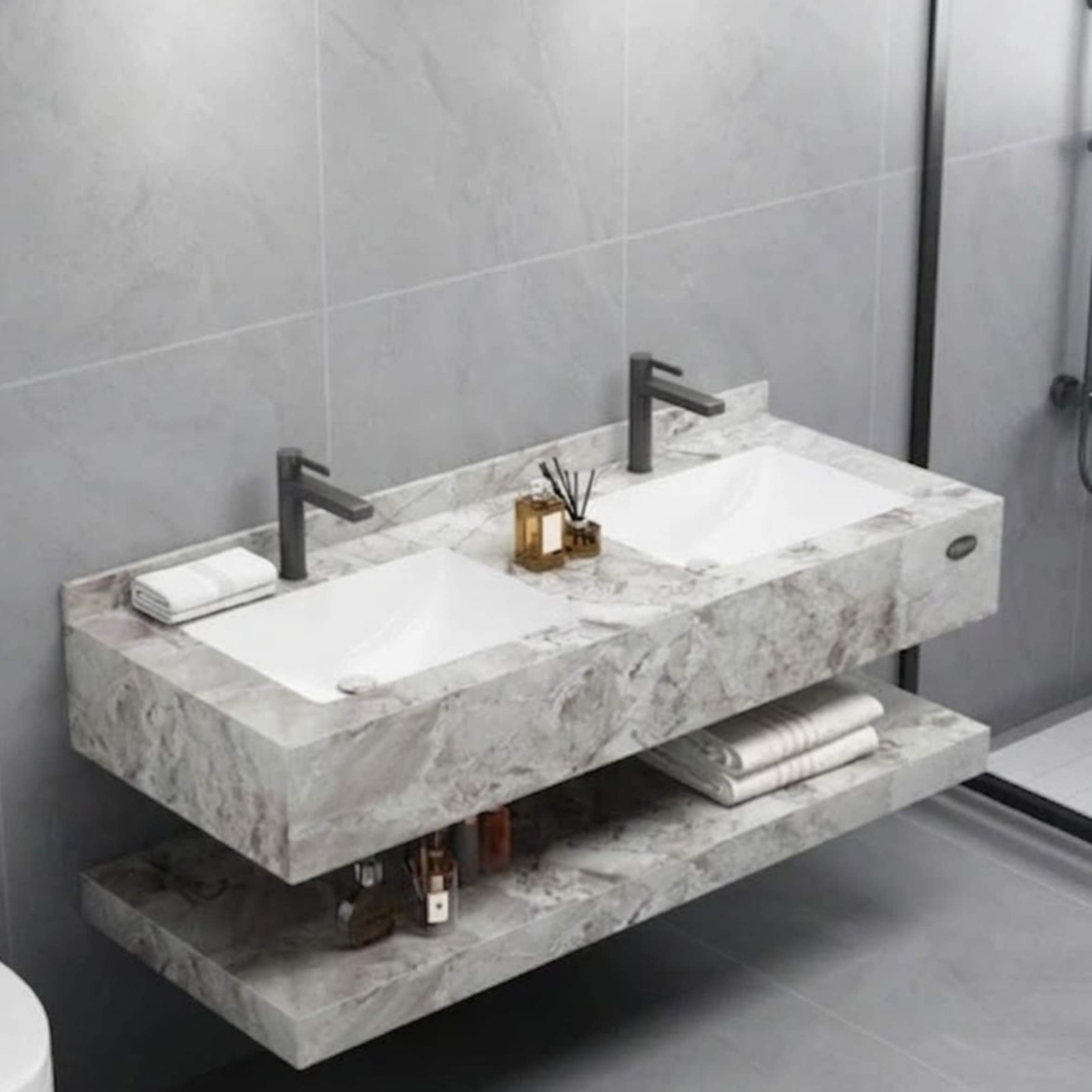 A floating double bathroom vanity clad in grey marble with two integrated rectangular white sinks and dark faucets from alwakil.ae